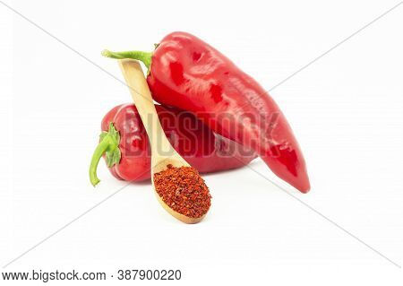 Fresh Capia Peppers And Chili Flakes Or Powder In Wooden Spoon Isolated On White Background, Healthy