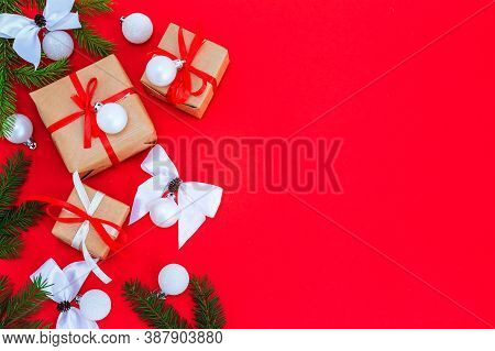 Christmas Composition, Fir Branches With Gifts, White Decorations On A Vertical Red Surface, Space F