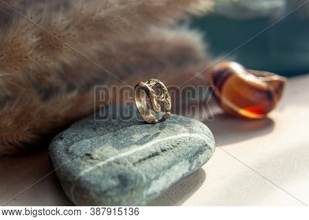 Trendy Vintage Cast Brass Ring. Jewelry Womens Ring Abstract Drawing Closeup On A Gray Natural Stone