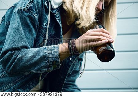 A Drunked Woman Dressed Punk, Informal Drinking Beer From A Brown Bottle, Alcohol Overdosage And Add
