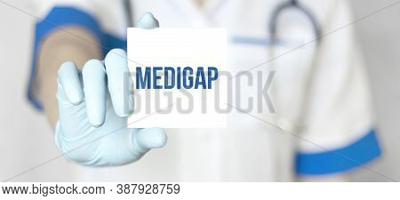 Doctor Holding A Paper Plate With Text Medigap Medical Concept