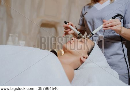 Lateral View Of Woman Facial Massage Spa Procedure. Electric Stimulation Facial Skin Care. Microcurr