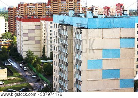Facade Of Old Urban Multi-storey Residential Panel House In Moscow. A Lot Of Wires On The Roof Of Th