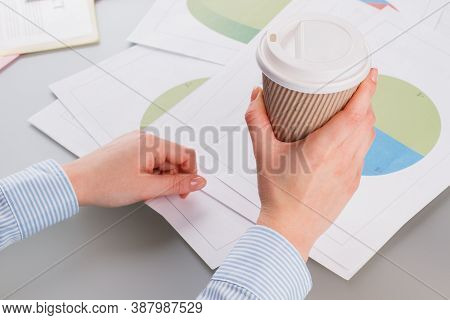 Close Up Female Hands Checking Documents At Office. Business Woman Holding Coffee Papercup While Wor