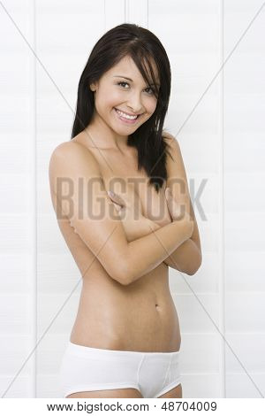 Portret topless uśmiechający się młoda kobieta obejmujące piersi z rękami