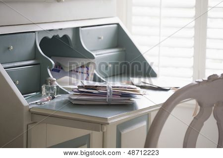 Letters tied up on writing desk at home