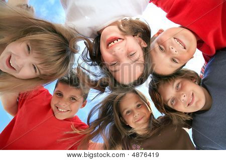 Happy Kids Huddling And Looking Down