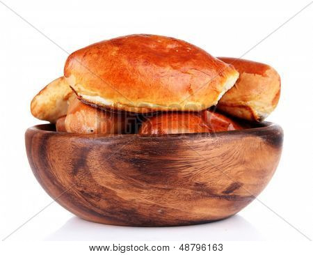 Empanadillas al horno frescas en un recipiente de madera, aislados en blanco