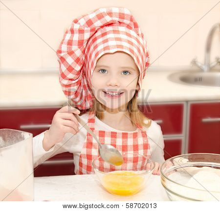Smiling Little Girl With Chef Hat Stirrring Cookie Dough