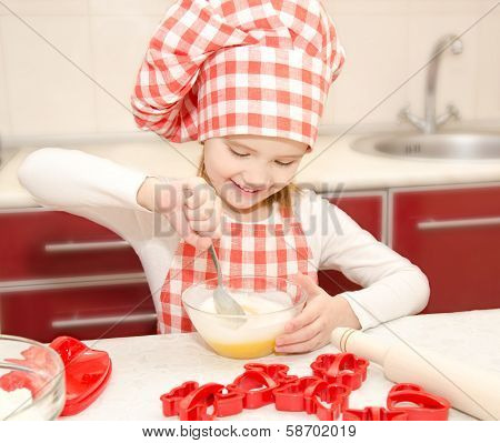Smiling Little Girl With Chef Hat Stirrring Cookie Dough