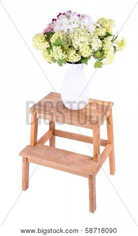 Vase with flowers on small wooden ladder, isolated on white