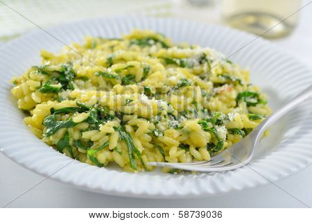 Spinach risotto with saffron and grated Parmesan cheese
