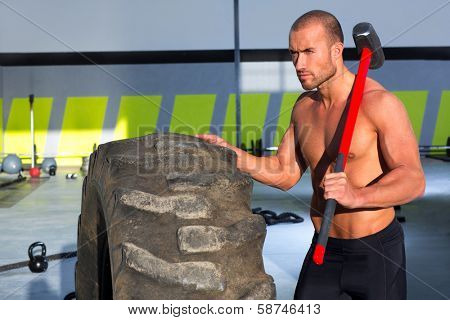 Crossfit sledge hammer man workout at gym relaxed after exercise