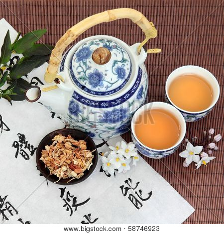Jasmine flower tea with oriental style teapot, cups and spoon and chinese calligraphy. Su xin hua.