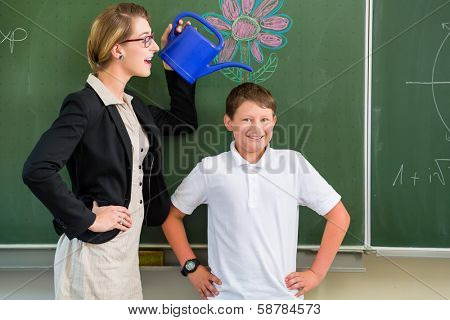 Teacher motivating school student in front of the board