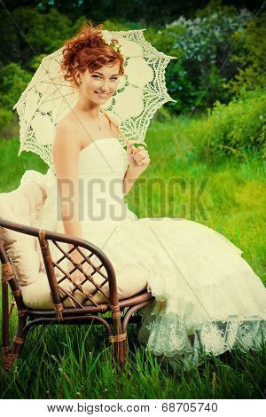 Beautiful smiling bride with chaming red hair. Wedding dress and accessories. Wedding decoration. 