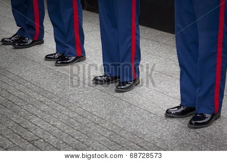 NEW YORK - MAY 23, 2014: Blue trousers with the scarlet blood stripe of four U.S. Marines Corpsmen participating in the re-enlistment and promotion ceremony at the National September 11 Memorial site.
