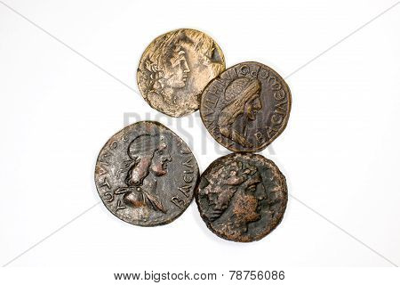 Four antique coins on a white background