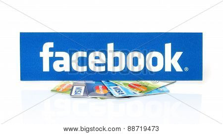 KIEV UKRAINE - MARCH 21 2015: Facebook logo printed on paper and placed on cards Visa and MasterCard