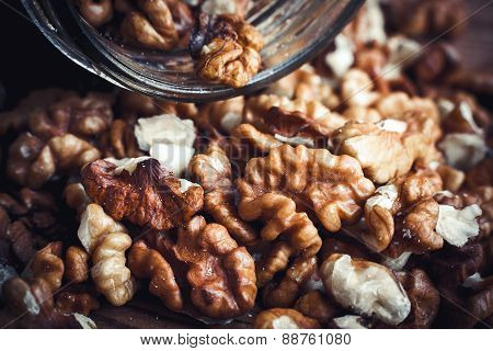 Walnut kernels and whole walnuts wood background
