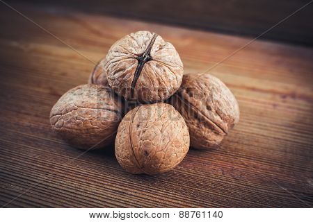 Walnut kernels and whole walnuts wood background