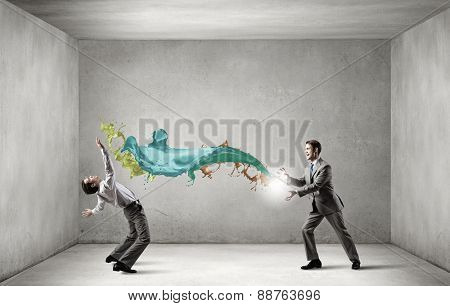 Young businessman trying to evade from thrown splashes