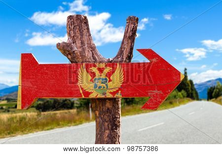 Montenegro Flag wooden sign with road background