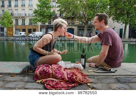 Couple enjoys lunch on the banks of the Canal Saint-Martin in Paris