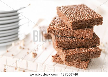 Delicious chocolate rice crispy treats on wooden board