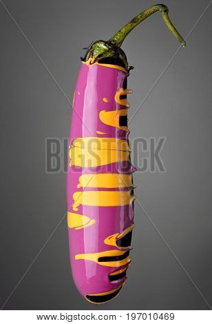 Eggplant With Pouring Yellow And Purple Paint On Gray Background. Fashion Food Concept.creative.