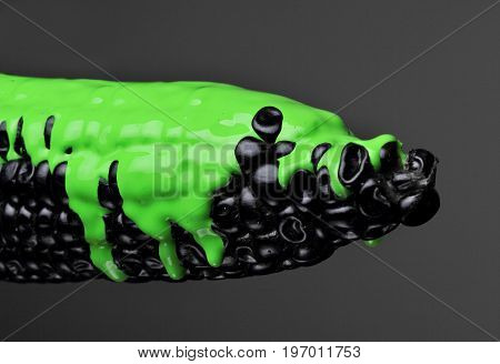 Black corn with pouring green paint background, macro closeup.Texture