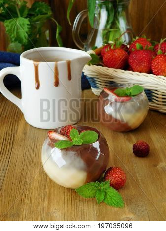Chocolate sauce in little tasters and strawberries in the background