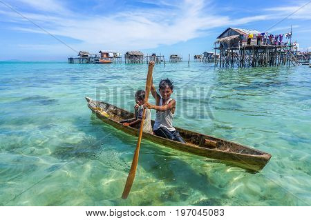 Semporna,Sabah,Malaysia-Apr 23,2017:Sea Gypsy kids on unique handmade boats with clear water on at Bodgaya island,Semporna,Sabah,Malaysia.