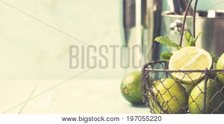 Mojito cocktail ingredients (fresh mint, lime, ice) on rustick background