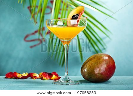 Summer  Cocktail -  Pornstar Martini. Drink with Passion fruit, Vodka, Liquor, Vanilla Syrup, Champagne and Lime Juice. Tropical Leaf on Background