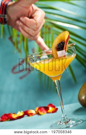 Summer  Cocktail -  Pornstar Martini. Drink with Passion fruit, Vodka, Liquor, Vanilla Syrup, Champagne and Lime Juice. Tropical Leaf on Background