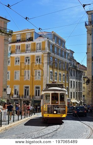 Lisbon Portugal - June 11 2017: Vintage tram famous number 28 route on the streets of romantic old Alfama. Rua da Madalena Lisbon Portugal