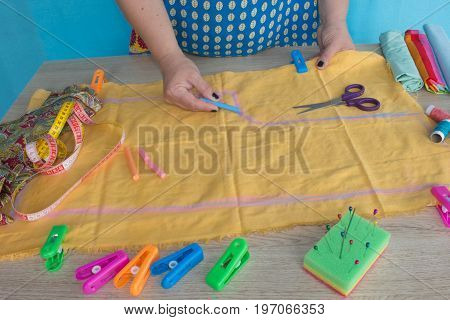Tailor woman working in his tailor shop Tailoring. A tailor is laying out a dress/Sewing layout