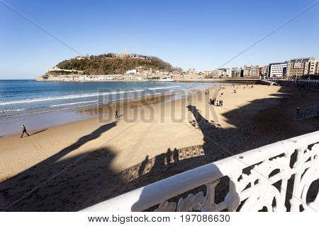 DONOSTI, SPAIN-DECEMBER 21 2014: On sunny days the people of Donosti take the opportunity to stroll along La Concha Beach on 21 December, 2014