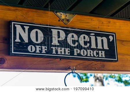 Too Much Regulation!  Sign No Peein' off the Porch on rafter of local watering hole's porch