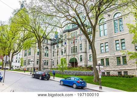 Quebec City Canada - May 29 2017: Old town street with Hotel de Ville City Hall cobblestone road with flags