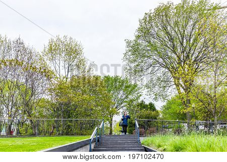 Quebec City Canada - May 29 2017: Young woman by stairs or steps in sidewalk by park in old town