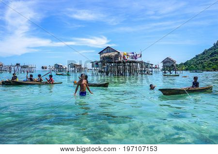 Semporna,Sabah,Malaysia-Apr 23,2017:Sea Gypsy kids on unique handmade boats surrounded by beautiful clear water of the Bodgaya island,Semporna,Sabah,Malaysia.