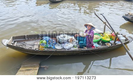 Can Tho, Vietnam - January 22, 2017: Food vendor selling noodles on the boat serving farmers in agricultural trade floating market in Can Tho, Vietnam