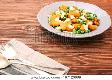 Warm salad with roasted pumpkin, peas and cheese brie. Low fat healthy eating concept.