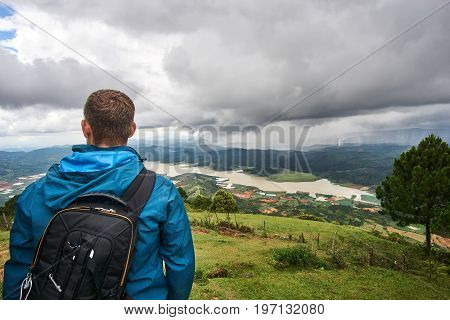 Young man standing on the mountain lang biang in Da-lat, Vietnam. Dramatic sky before the rain starts