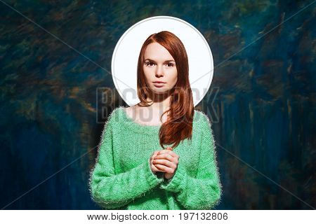 young pretty redhead teen in greem pullover over dark blue background. beauty model woman with luxurious red hair. hairstyle. holiday makeup