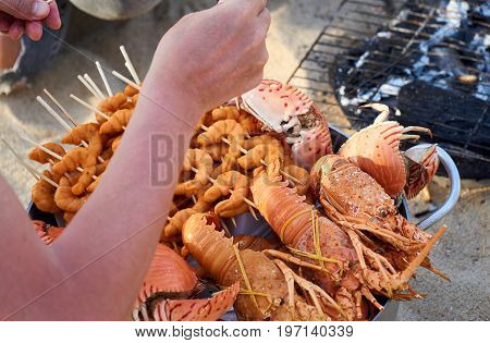 Vietnamese seefood grilled on fire at directly at the beach in Nha Trang, Vietnam