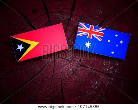 East Timorese Flag With Australian Flag On A Tree Stump Isolated