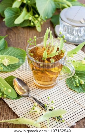 Lime flower tea in glass cup with linden flowers. midicinal remedy.